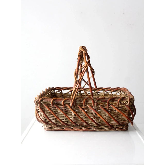 This is a vintage wicker basket. The large woven rectangle basket has a one-of-kind decorative bentwood "cage" around its...