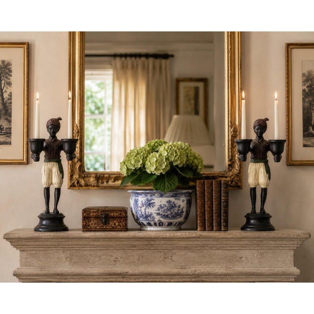 A characterful pair of late-20th-century figurative candleholders cast in iron and retaining their original painted...