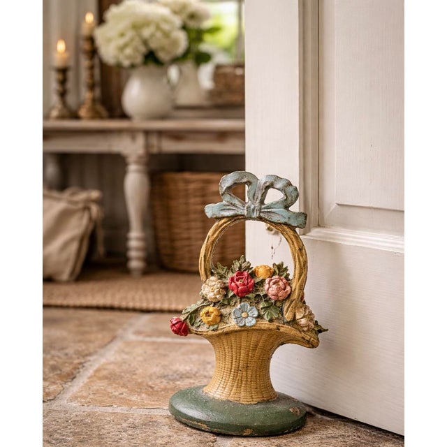 A charming vintage cast iron doorstop in the form of a woven basket overflowing with florals, finished in its original...