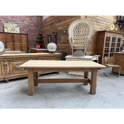 This 1960s oak farmhouse table has been fully restored. It features a thick tabletop and a sturdy base with a crossbar....