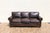 A timeless three-seat leather sofa by Restoration Hardware, upholstered in rich brown leather with a beautifully aged...