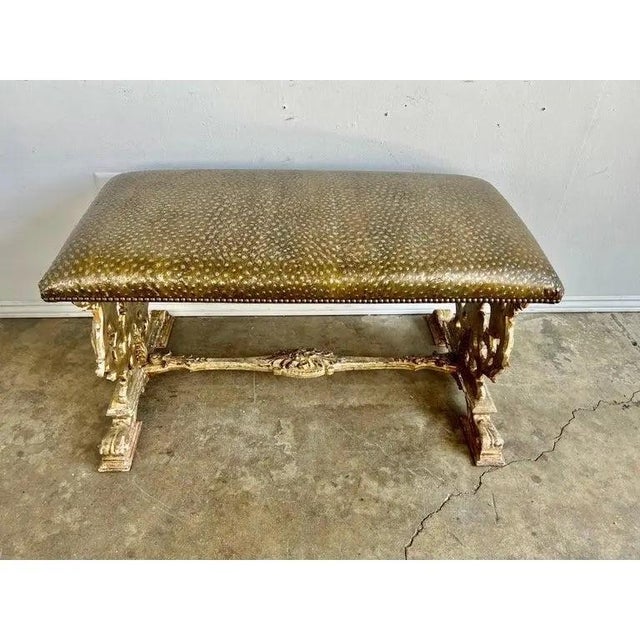 Midcentury silvered "X" style benches newly upholstered in faux embossed ostrich style gold washed leather. The benches...