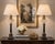 A striking pair of neoclassical Empire-style table lamps, showcasing a sophisticated blend of crystal, black marble, and...