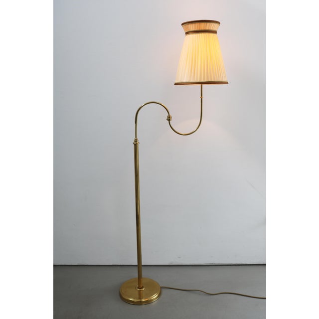 Swedish mid-century brass floor lamp, 1960s. Brass with pleated shade. Height 156 cm. Width with extended swivel arm 58...