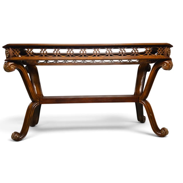 Elegant vintage console table featuring a beveled glass inset top, pierced geometric fretwork, gilt-tone rosette and...