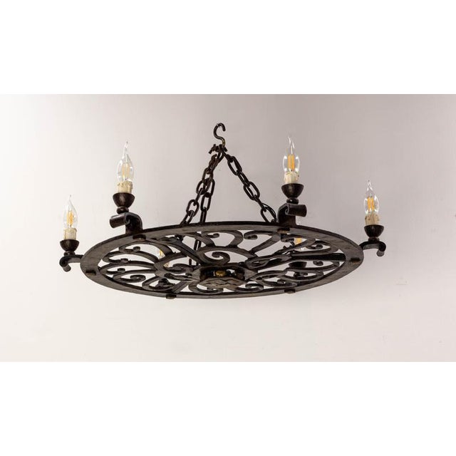 Large circular wrought-iron chandelier, France, circa 1940 An imposing French wrought-iron chandelier dating from the...