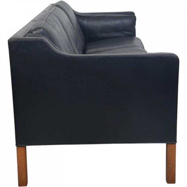 Børge Mogensen 2213 3.seater sofa upholstered in black leather, and with legs of teak. The sofa is from 1985 and appears...