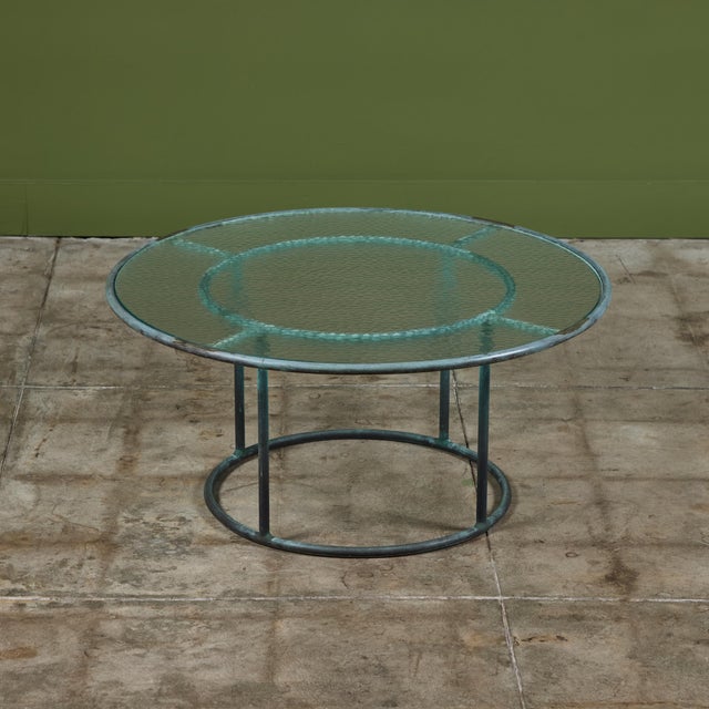 Patio coffee table in patinated bronze designed by Walter Lamb and produced by Brown Jordan. The frame is described by two...