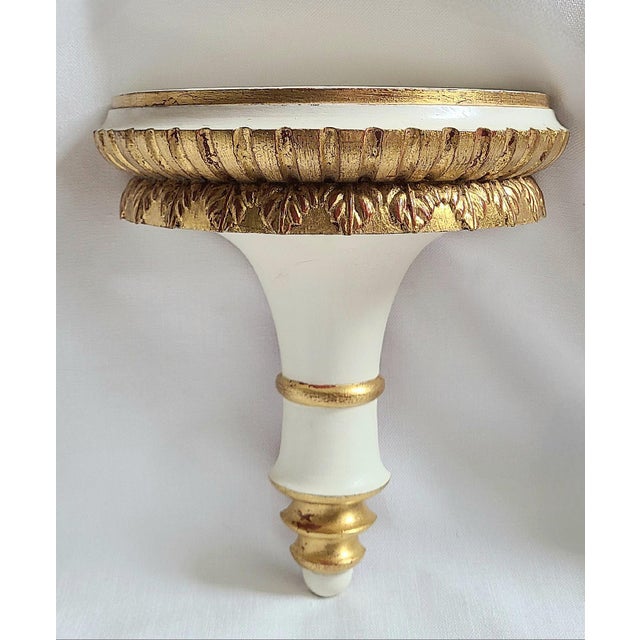 Pair of wood wall brackets finished in off white with hand applied gilt details