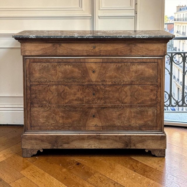 19th Century French Louis Philippe Burl Walnut Marble Top Commode is a beautifully composed piece, distinguished by its...