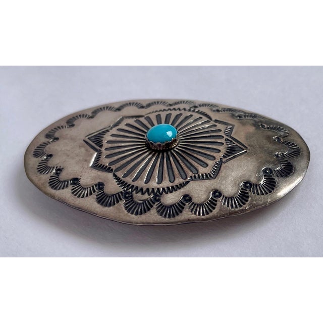 This is a beautiful sterling and turquoise pin with a classic stamped design. On the back, it is stamped WS and sterling.