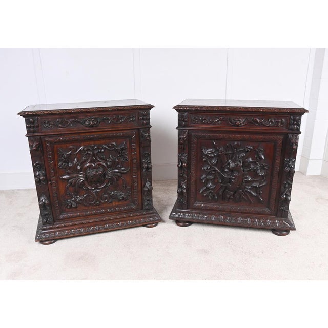A striking pair of German Black Forest carved oak cupboards, dating to around 1860. Each cabinet is richly decorated with...