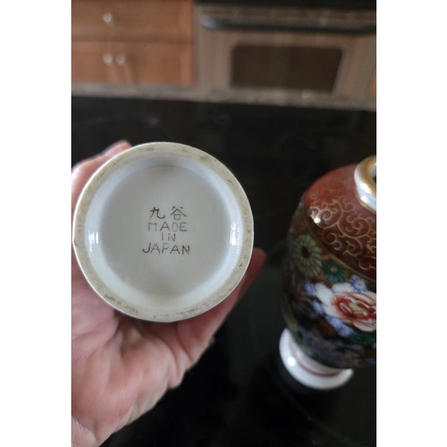 Charming and finely detailed, this vintage pair of Japanese Kutani porcelain bud vases showcases the rich colors and...