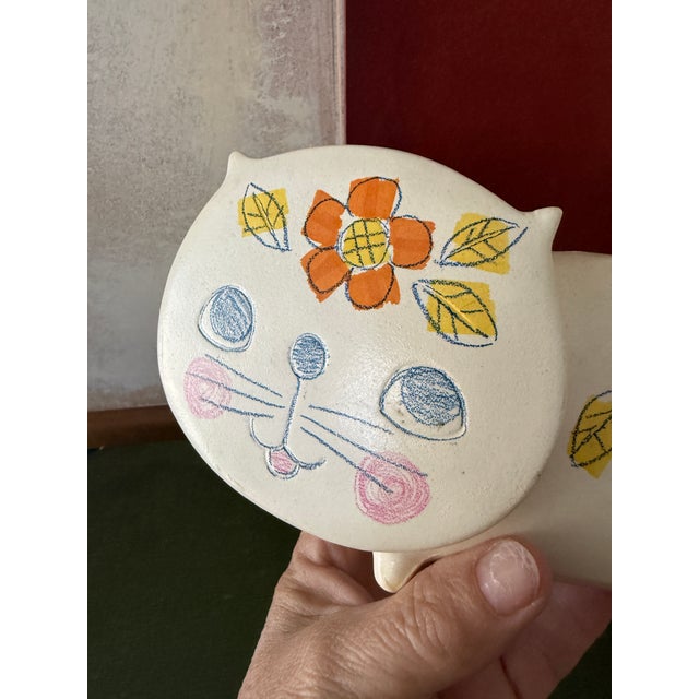 This charming vintage ceramic piggy bank is shaped as a sweet kitty cat and was made in Japan by Wales. Decorated with a...