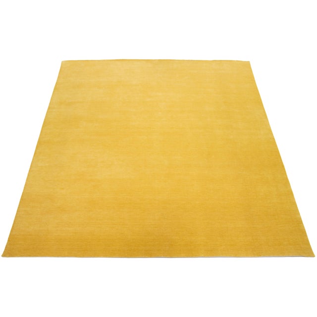 This handcrafted custom wool rug, designed in the Gabbeh style, features a solid light yellow design. It is part of our...
