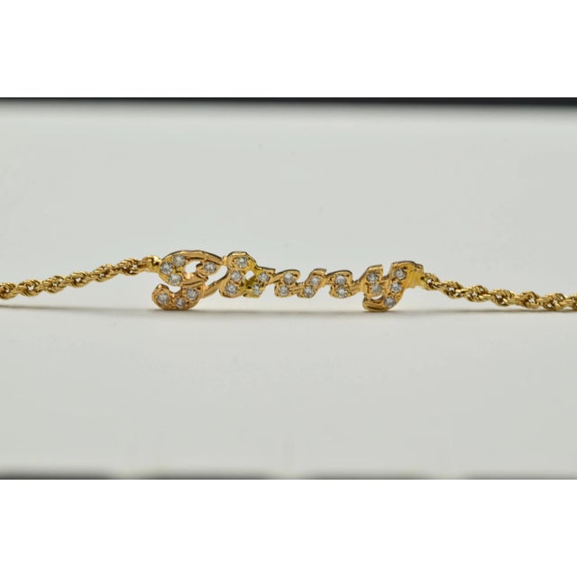The Ginny Ladies Signature Name Anklet set with Diamonds. This anklet is crafted in 14 karat yellow gold and features 0.25...