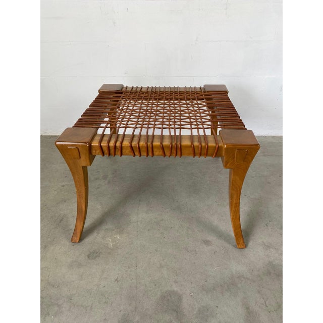 T.H. Robsjohn-Gibbings Klismos stool with original woven leather strap seats, 1960s, produced by Saridis of Athens. This...