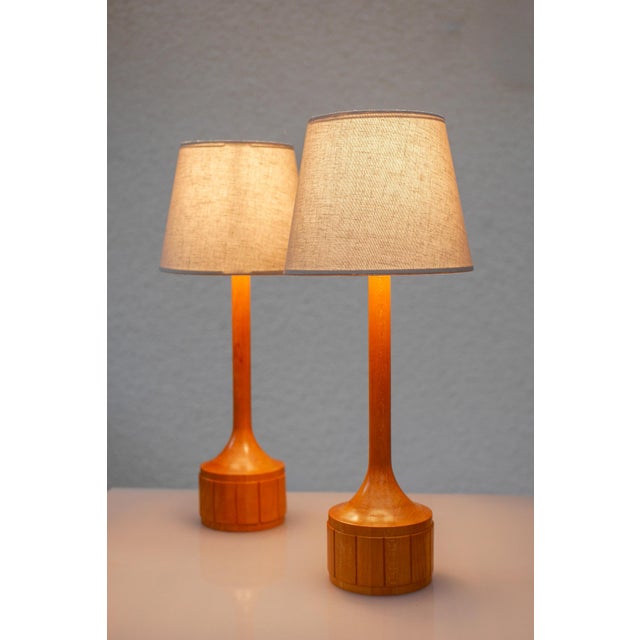 A striking and elegantly proportioned pair of vintage Swedish oak table lamps, designed and produced in the 1960s by Elpe...