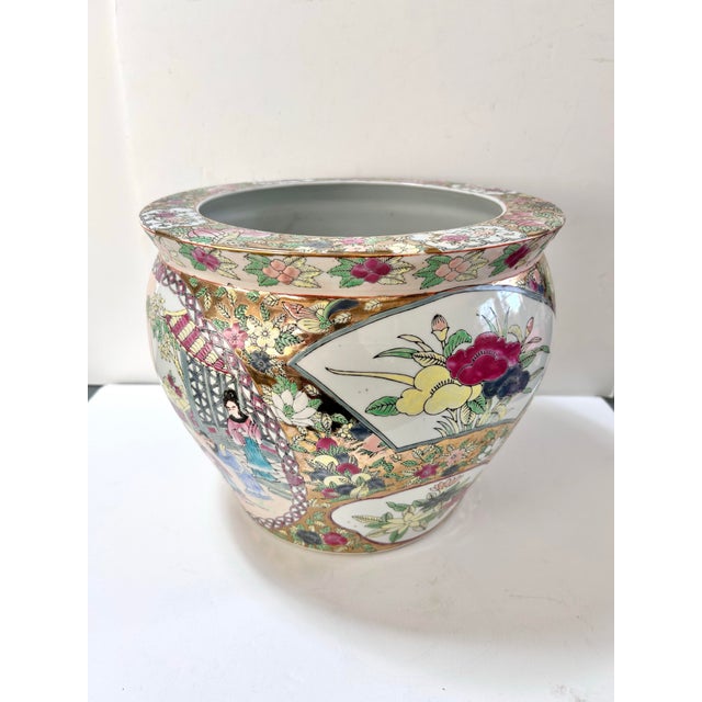 This large vintage Chinese porcelain fishbowl planter features vibrant famille rose style decoration with floral panels,...
