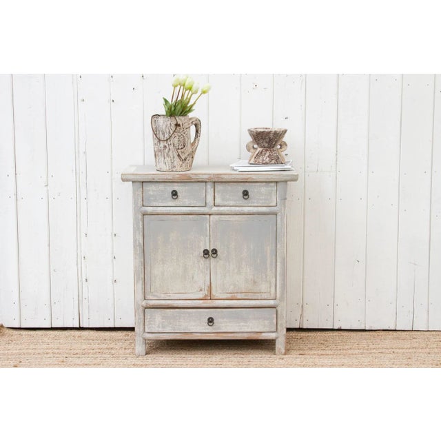 A light gray painted cabinet made from reclaimed wood, this cabinet is the perfect piece to add a touch of rustic charm to...