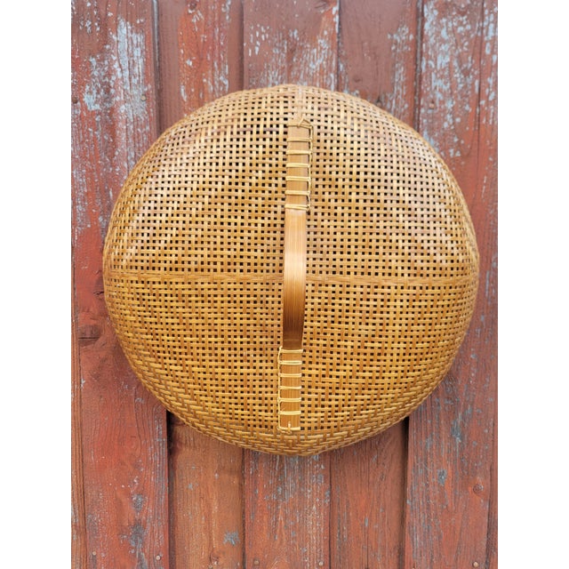 Vintage hand‑woven bamboo basket showcasing traditional craftsmanship and warm natural texture. It features a tight...