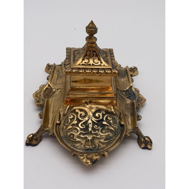 Elevate your workspace with this handsome vintage solid brass inkwell stand, featuring striking Baroque and Rococo-style...