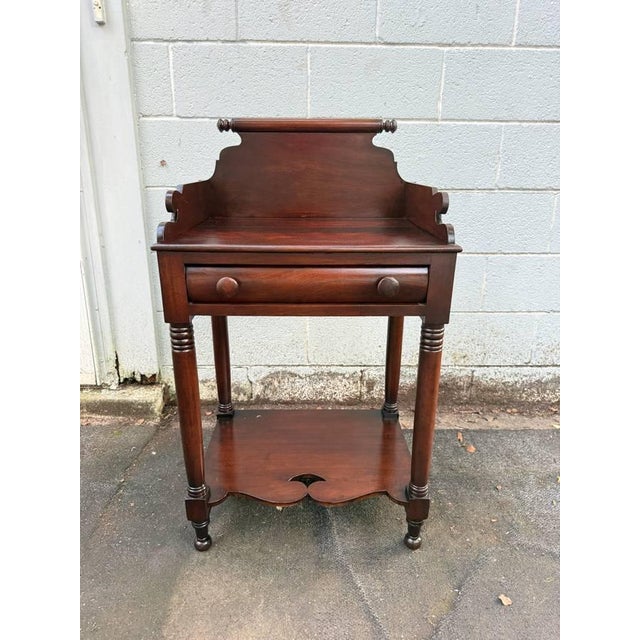 Antique 19th Century Early American Empire Style Mahogany One Drawer Wash Stand Side Table. It features mahogany two-tier...