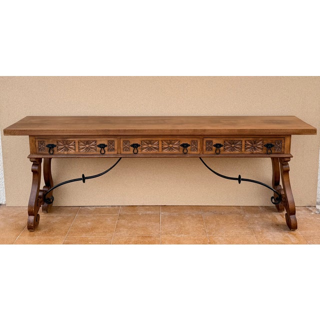 The long rectangular top sits above a richly decorated frieze featuring a series of carved geometric and floral motifs,...