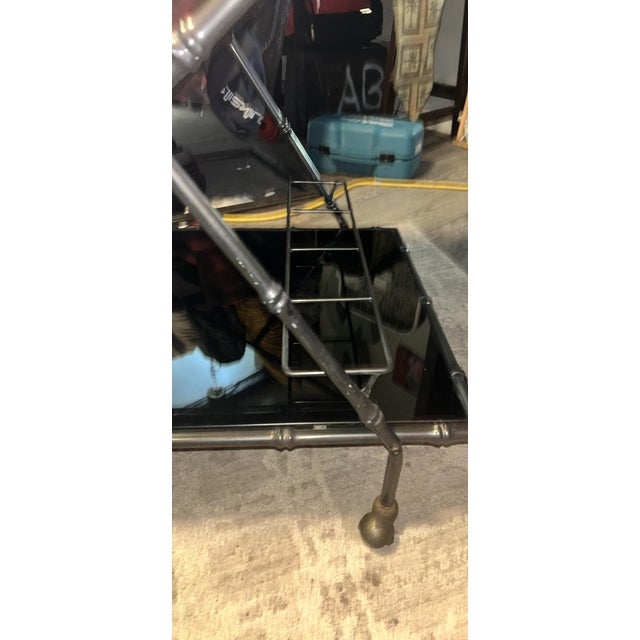 Chic Italian rolling bar cart having a black anodized metal faux bamboo frame. Hollywood Regency design with a modern...