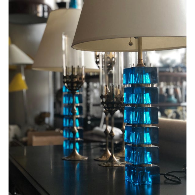 A pair of table lamps by Carl Fagerlund for Orrefors, Sweden, circa 1960s. Blue glass cubes and brass fittings. Measures:...
