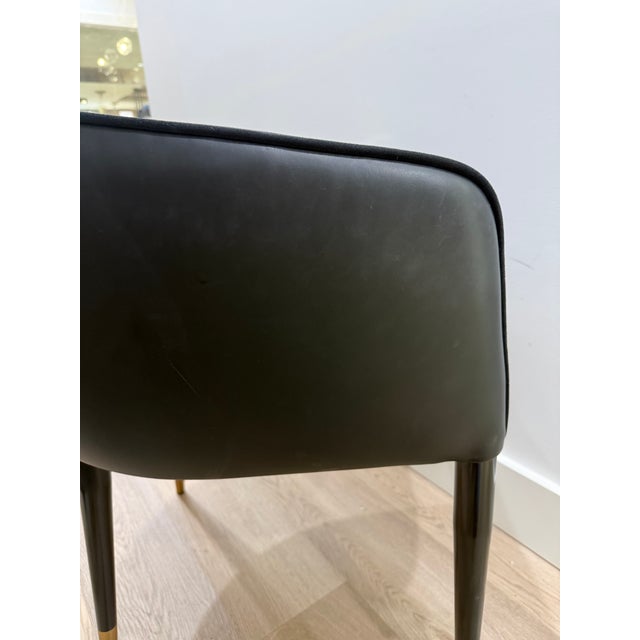 A modern barrelback dining armchair from our Ikon collection, upholstered in Abbington black fabric and contrasting napa...