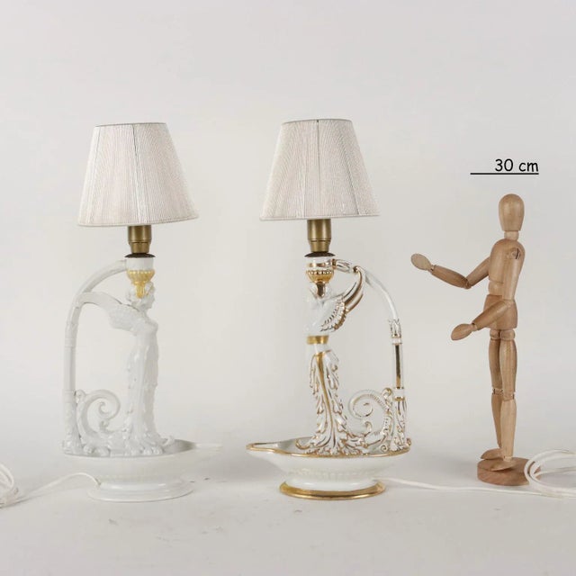 Pair of neoclassical -style porcelain lamps with a winged figure. Golden brown only on a lamp. Under the brand of the...