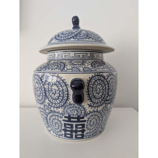 Stamped double happiness lidded ceramic jar in the classic chinoiserie style. In like-new condition. Opening of the vessel...