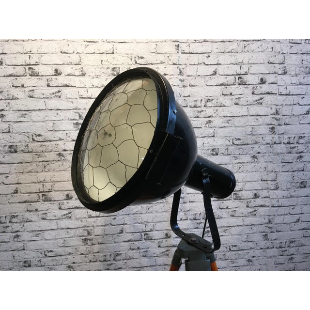 This industrial reflector stands on a wooden tripod and was produced during the 1950s in former Czechoslovakia. It is...