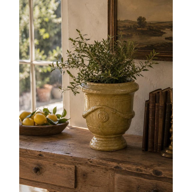 A handsome late 20th century French Provincial earthenware planter with a warm ochre glaze, softly crackled surface, and...
