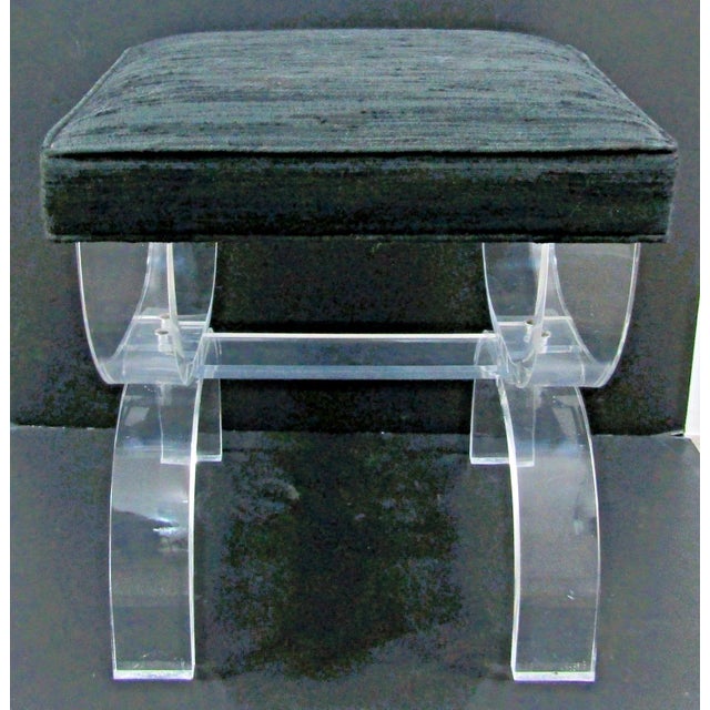 This vintage Lucite and black upholstery vanity stool features thick curved legs in an X-style design, giving it a unique...
