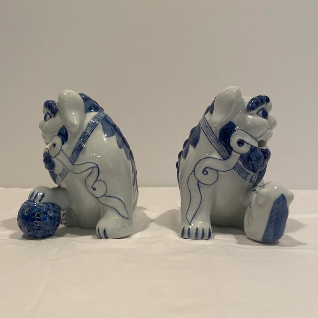 Charming pair of vintage Foo Dogs in blue and white. Foo Dogs are guardian lion-like figures which originated in China and...