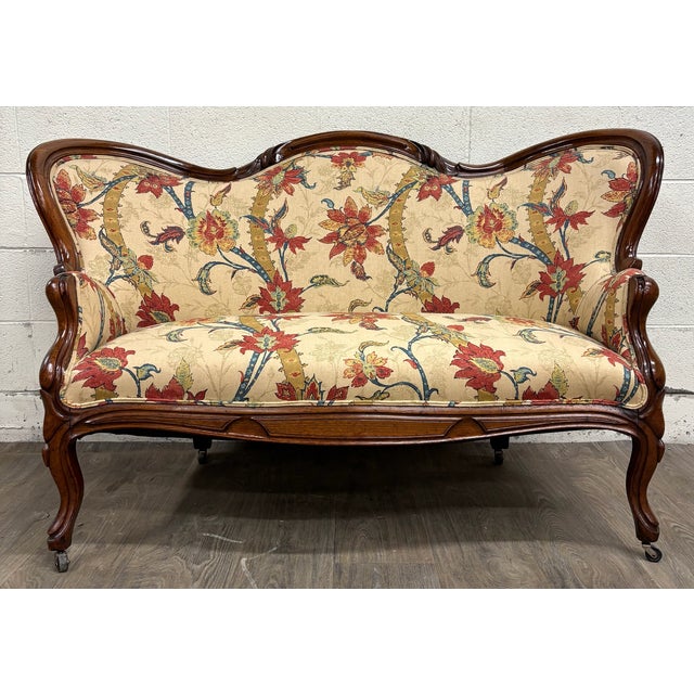This is a gorgeous antique late 19th-century (1800s) Victorian parlor settee featuring a richly finished exposed walnut...