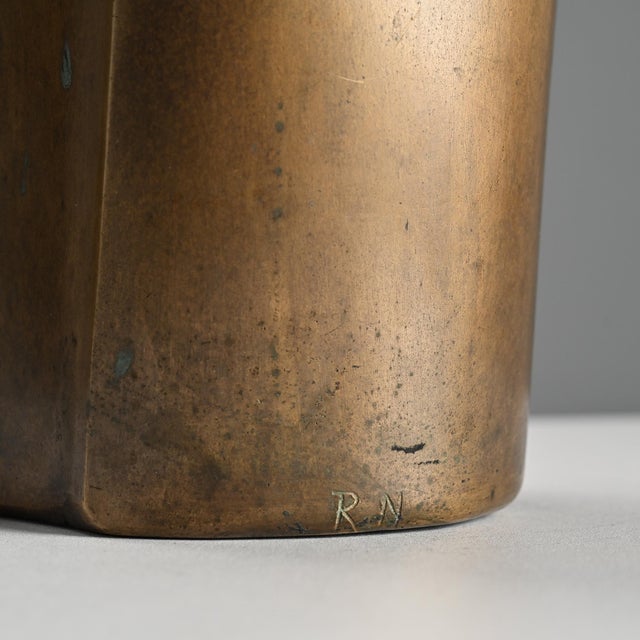 Bronze sculpture signed by Robert Neuhauser, created in Switzerland in the 1980s. The piece consists of a vertical volume...
