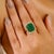 This luxurious Princess Diana inspired ring showcases a stunning emerald-cut emerald weighing 7.22 carats, artfully set in...