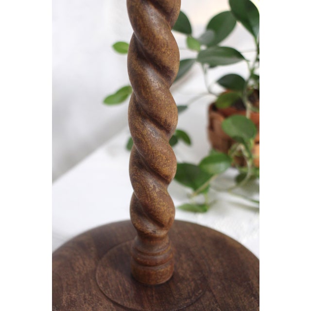 A barley twist or spiral column stand with an round top in dark wood. Perfect for a plant or to showcase a sculpture or as...