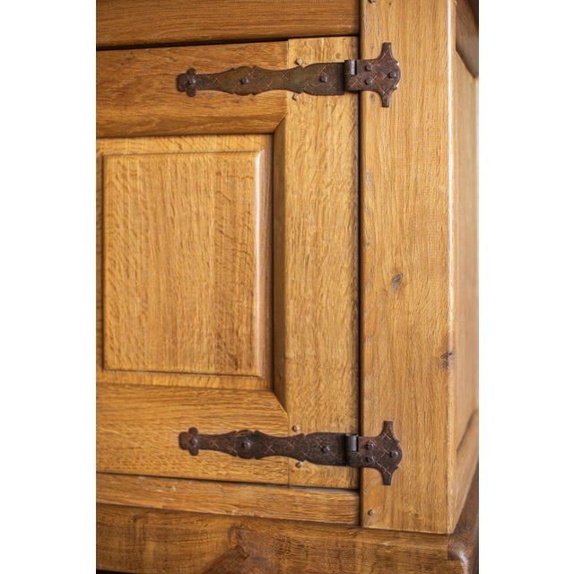 This mid-1900s large rustic French light oak sideboard showcases the warmth and character of solid oak construction,...