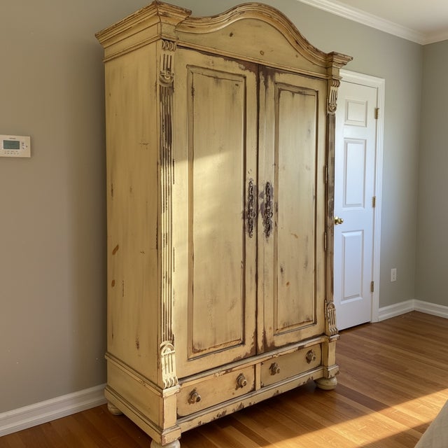 Habersham Plantation armoire with a beautifully distressed cream-yellow painted finish and classic European country...