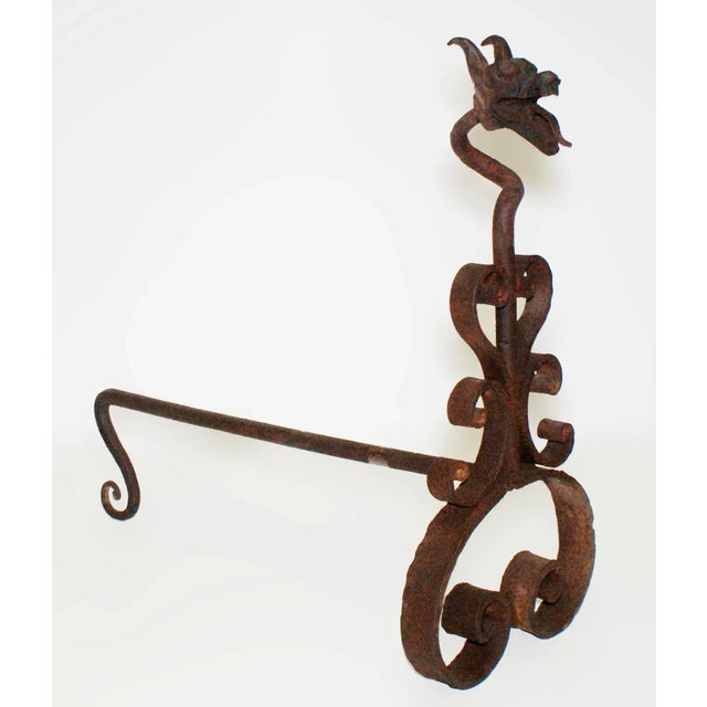 Rare, antique late 19th century folk art wrought iron andirons. Scroll motifs and grotesque head finials.