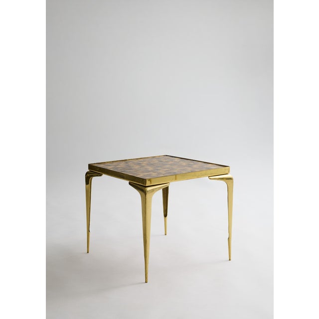 Pair of vintage mosaic-top side tables featuring earthy-tone mosaic surfaces and tapered brass legs with an aged patina....