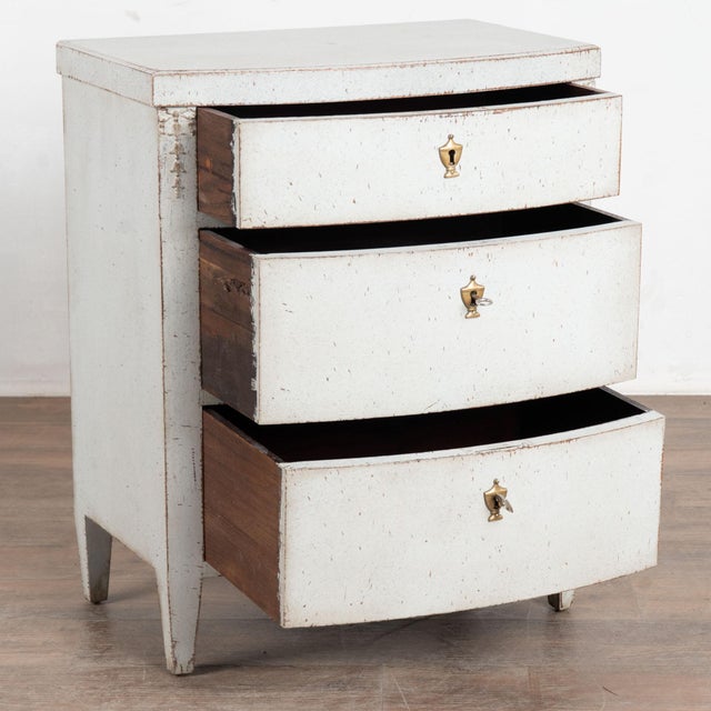 19th century Danish Empire small chest of three drawers or nightstand, crafted in oak. The case has a gentle bow front...