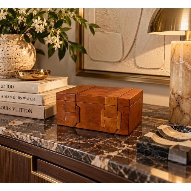 Handsome vintage decorative storage box wrapped in warm cognac-brown leather, featuring distinctive layered leather strap...