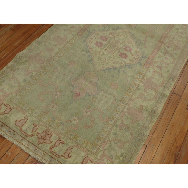 An antique Turkish Oushak small runner from the early 20th century in soft green and pinks 3'4'' x 6'