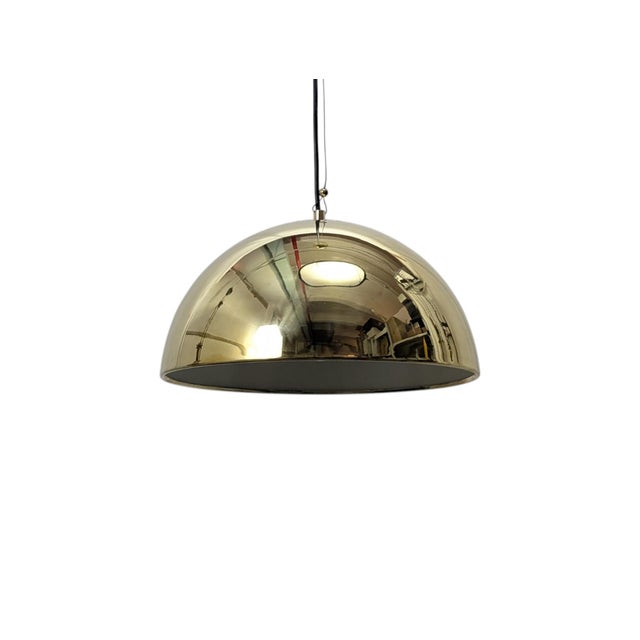 This is a mid-century pendant lamp from the 1970s. It features a polished, reflective brass dome shade suspended from a...