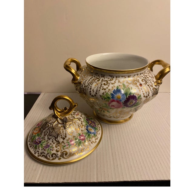 Beautiful hand painted and hand gilt round and broad urn with lid. the floral decoration with gilt handles, original lid...